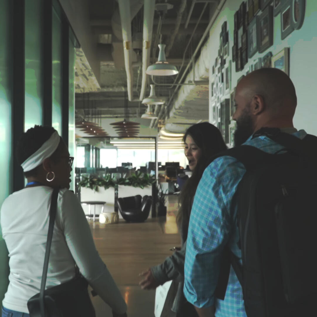 Image of employees happily walking down an office hallway